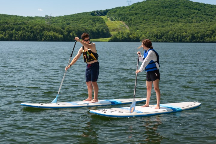 two young people paddleboarding together