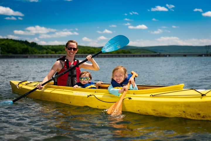 a mother and two children in a double kayak on Monksville Reservoir