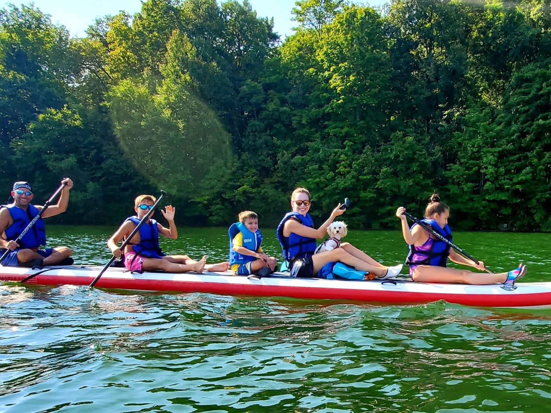 a group of people sitting down and paddling a dragon board in the water