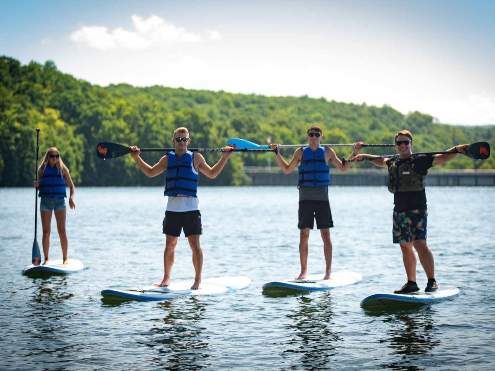 a group of people that are stand up paddle boarding in a lake with mountains in the background