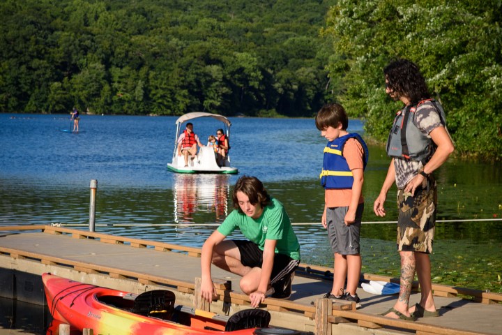 a group of people standing next to a body of water
