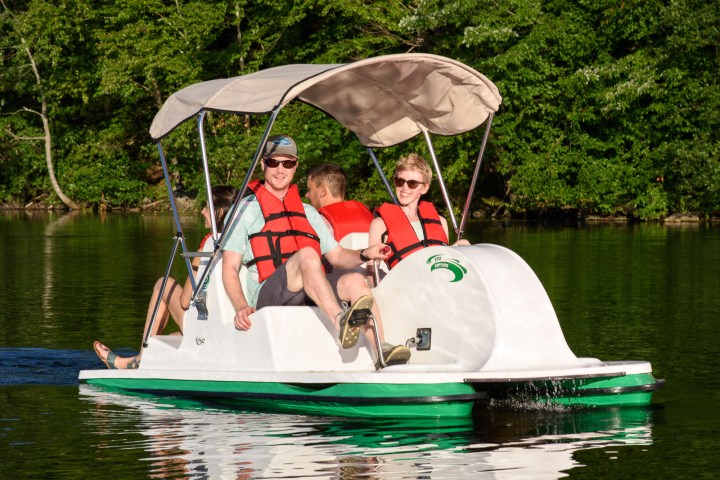 Matt McGloin et al. riding on the back of a boat in the water