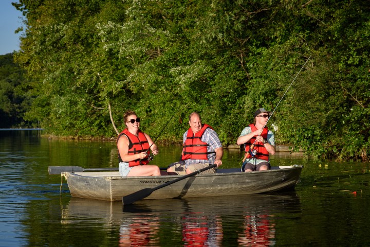three people fishing in a small rowboat on Shepherd Lake