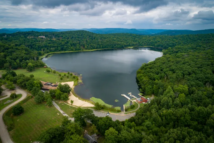 a large body of water surrounded by trees and a boathouse with docks