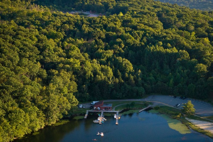 an aerial photo of a hillside next to a body of water