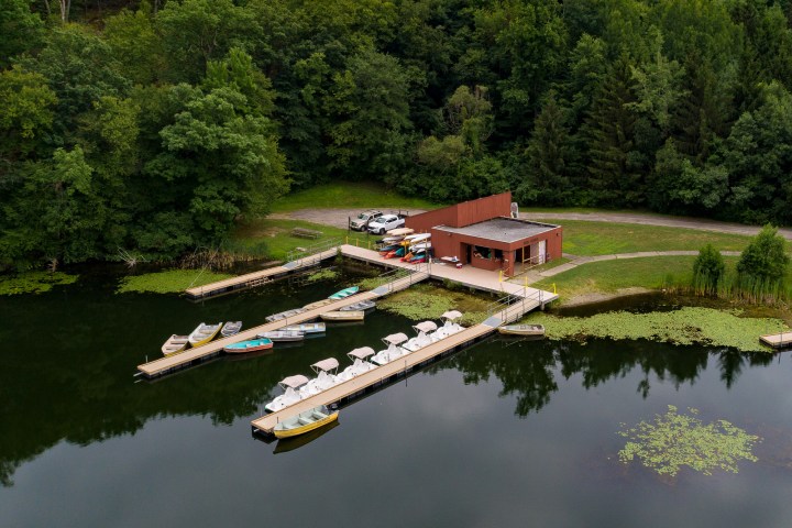 Shepherd Lake Boathouse is in the center of the photo, with docks stretching out onto the water and trees in the background
